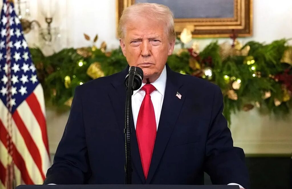 Donald Trump standing at a podium at the White House, waiting to deliver his speech after the incident involving Nicolás Maduro