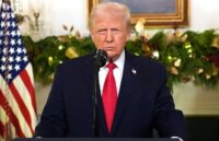 Donald Trump standing at a podium at the White House, waiting to deliver his speech after the incident involving Nicolás Maduro