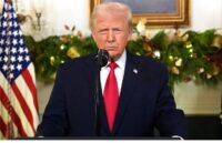 Donald Trump with a very serious expression standing in front of many people and cameras before making an announcement