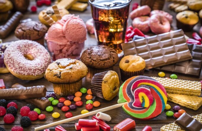 A table full of sweets, puddings, hamburgers, and many other ultra-processed foods