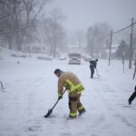 Four people clearing the roads with shovels after the recent snowstorms hitting the United States