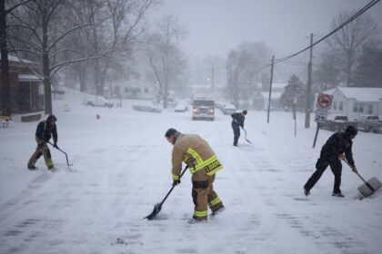 Four people clearing the roads with shovels after the recent snowstorms hitting the United States