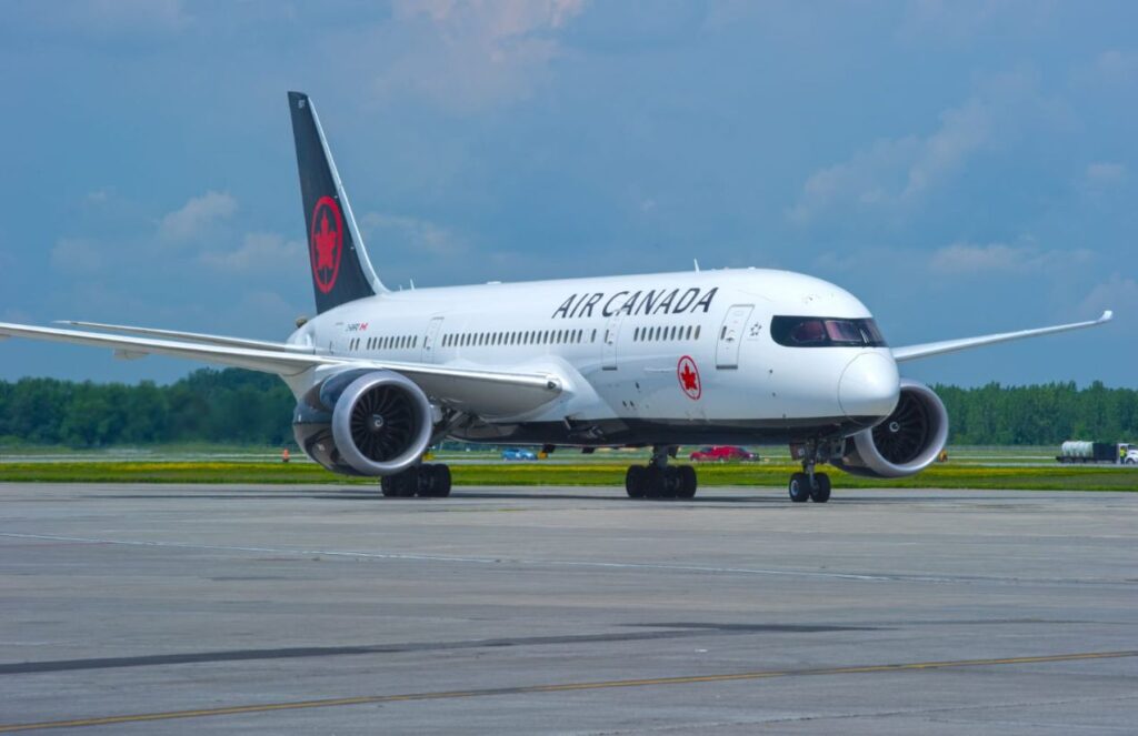 A white Air Canada aircraft on the runway, ready for takeoff