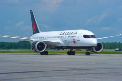 A white Air Canada aircraft on the runway, ready for takeoff