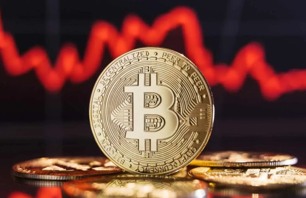 A physical coin representing Bitcoin with a red negative index in the background