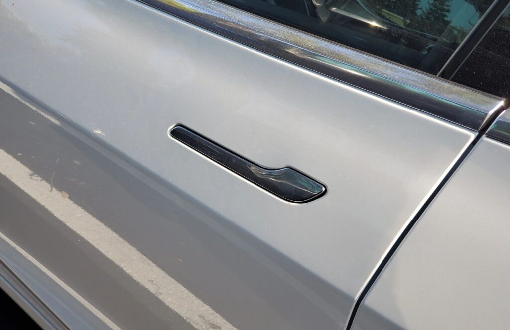 A gray car door with a hidden door handle
