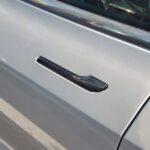 A gray car door with a hidden door handle