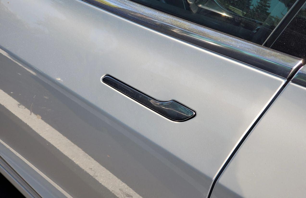 A gray car door with a hidden door handle