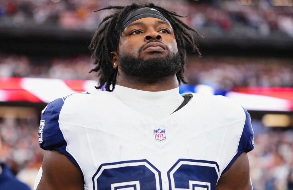 The Cowboys’ current running back standing mid-game, focused, looking toward the stands