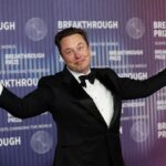 Elon on a red carpet posing for cameras while wearing an elegant suit
