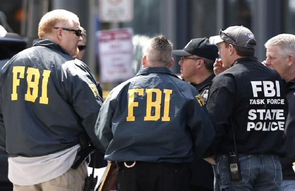 Several FBI agents talking among themselves while wearing FBI jackets