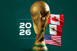 The World Cup trophy on a green set with the flags of Canada, the United States, and Mexico beside it