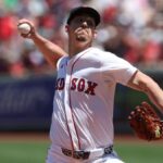 The now Padres player about to throw the ball from the mound while wearing a Boston Red Sox uniform