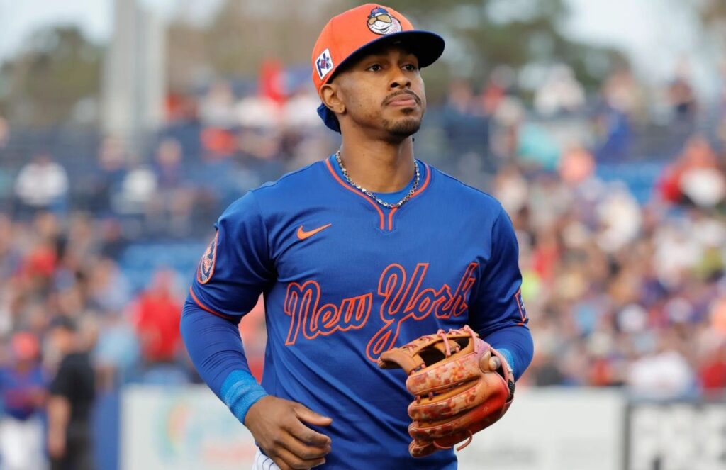 Lindor jogging to his position on the field wearing the Mets’ blue uniform