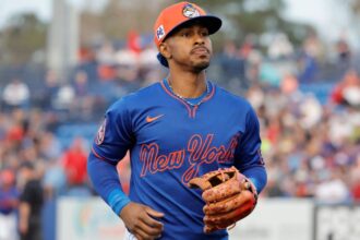 Lindor jogging to his position on the field wearing the Mets’ blue uniform