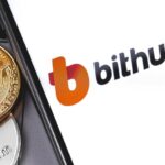 A cellphone opening the Bithumb platform, with several bitcoin coins next to it