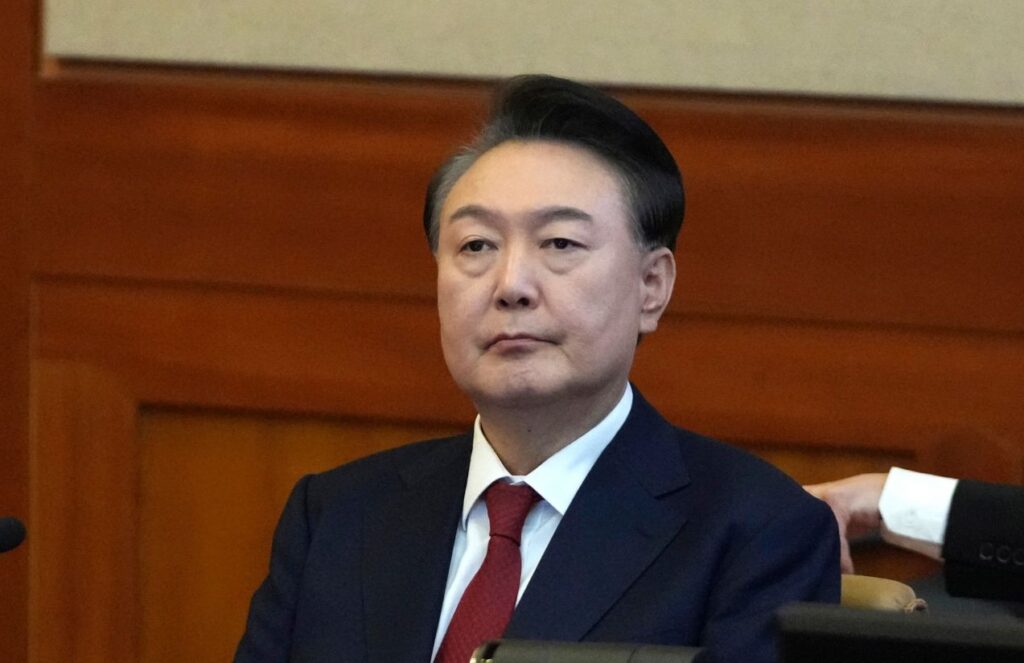 The former president of South Korea seated in court, listening and focused on what is happening around him