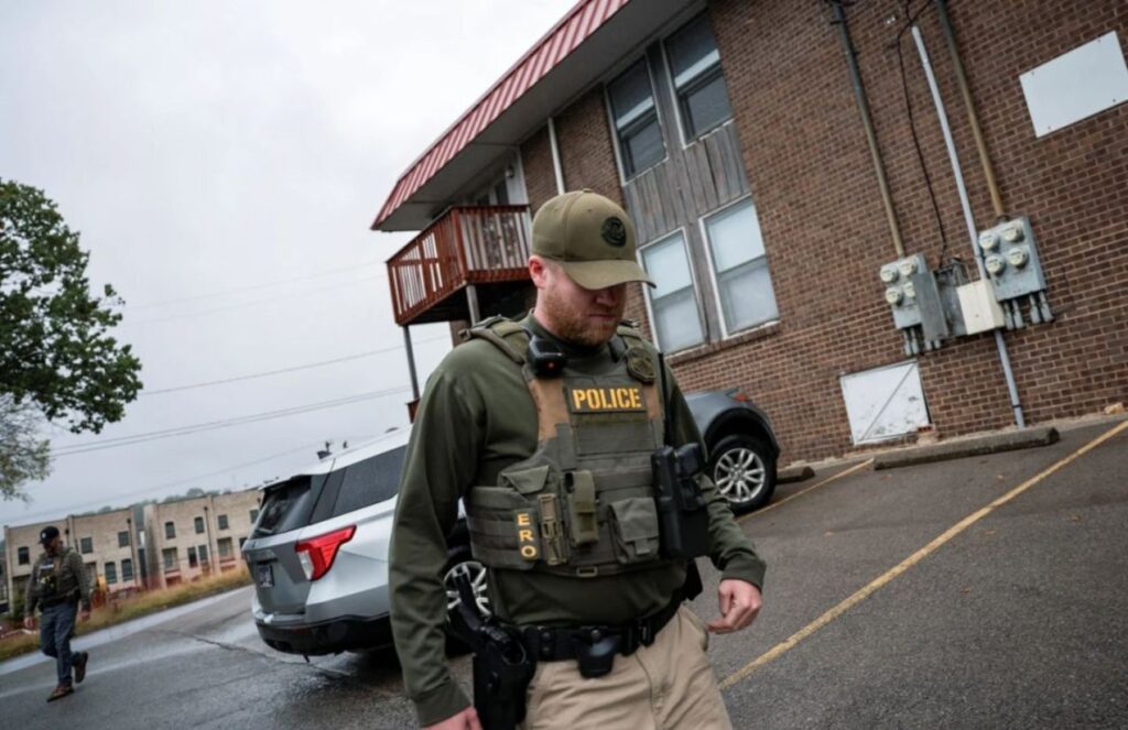 ICE agents accused of disguising themselves as workers during raids A police officer walking down a neighborhood street during a raid