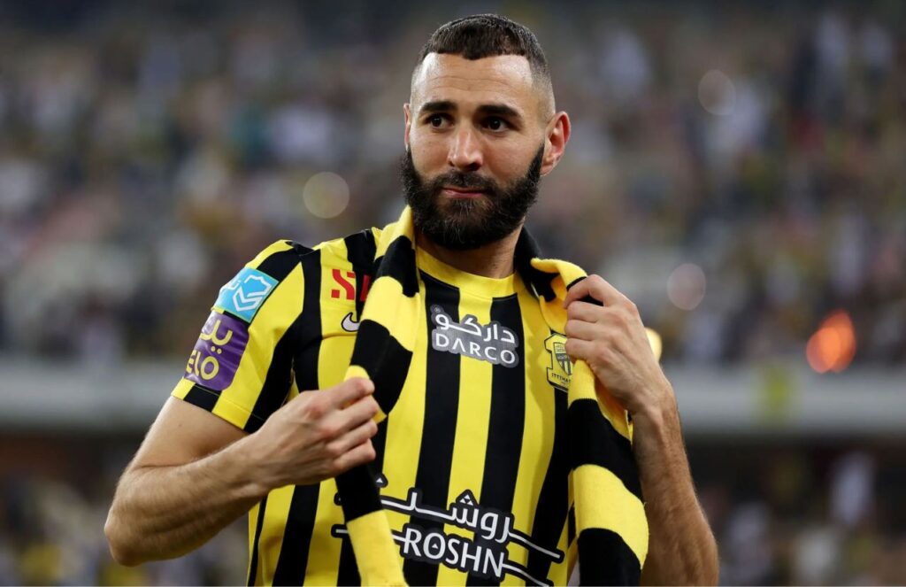 The French striker wearing a yellow kit with black vertical stripes