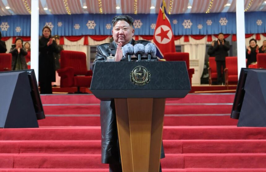 Kim Jong Un re-elected as top leader, consolidating his power in North Korea Kim Jong Un standing at a podium, speaking in front of all his followers, on a red carpet atop a platform