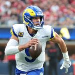 Stafford running with the ball during a game while wearing the Rams’ white uniform