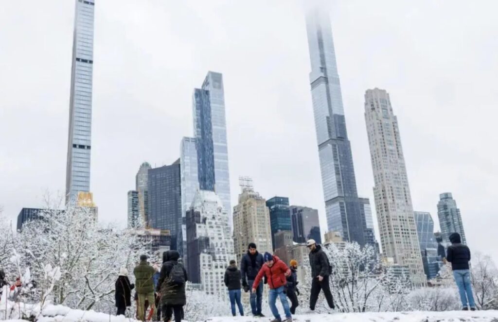 Several people enjoying a New York City blanketed by icy snow
