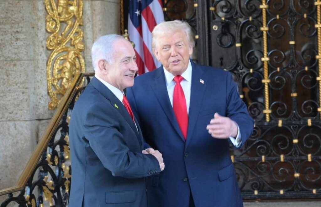 Trump and the Israeli prime minister cheerfully greeting each other on a staircase leading to a large black door