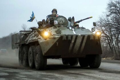 An armored Ukrainian vehicle with several soldiers outside as they approach their objective