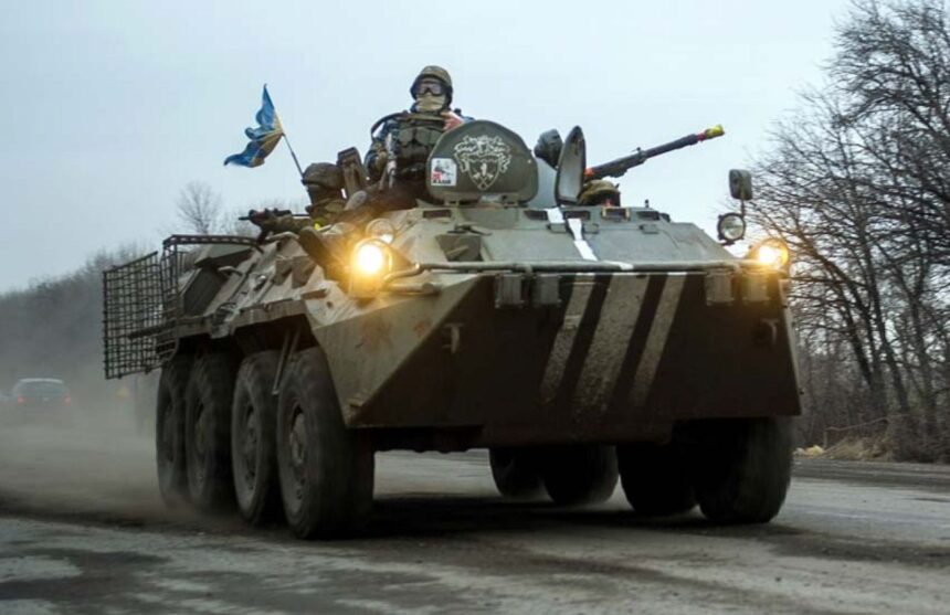 An armored Ukrainian vehicle with several soldiers outside as they approach their objective