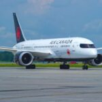 A white Air Canada airplane parked at an airport