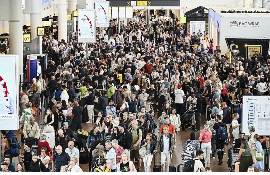 An airport crowded with people walking around, looking for their flights, and others waiting to board