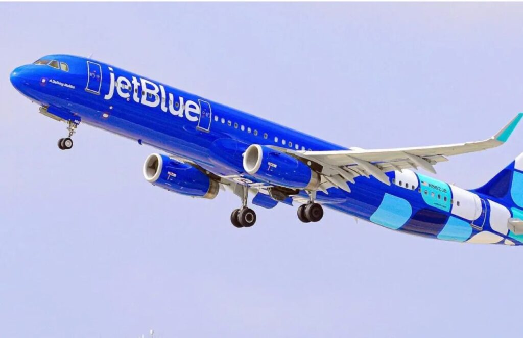 A JetBlue airplane with its characteristic royal blue color about to land at an airport