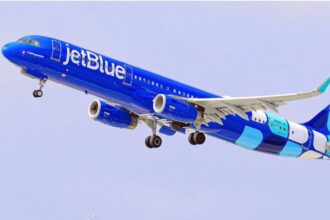 A JetBlue airplane with its characteristic royal blue color about to land at an airport
