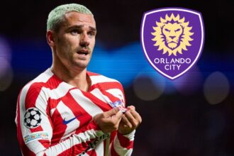 The famous French player kissing the crest on his jersey, with the purple crest of Orlando City SC next to him