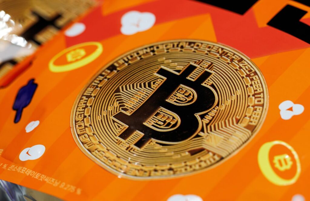 Bitcoin nears $72,000 and reignites the crypto market The Bitcoin logo placed on an orange table