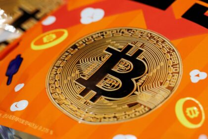 The Bitcoin logo placed on an orange table