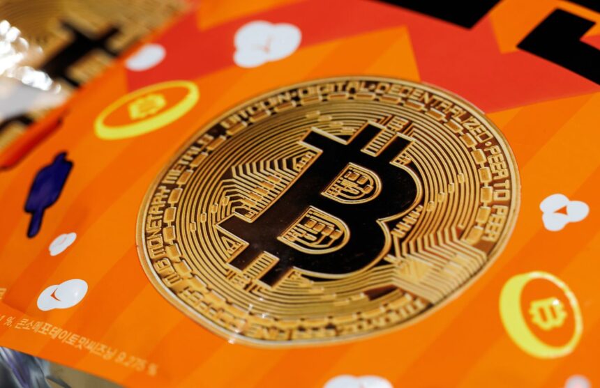 The Bitcoin logo placed on an orange table