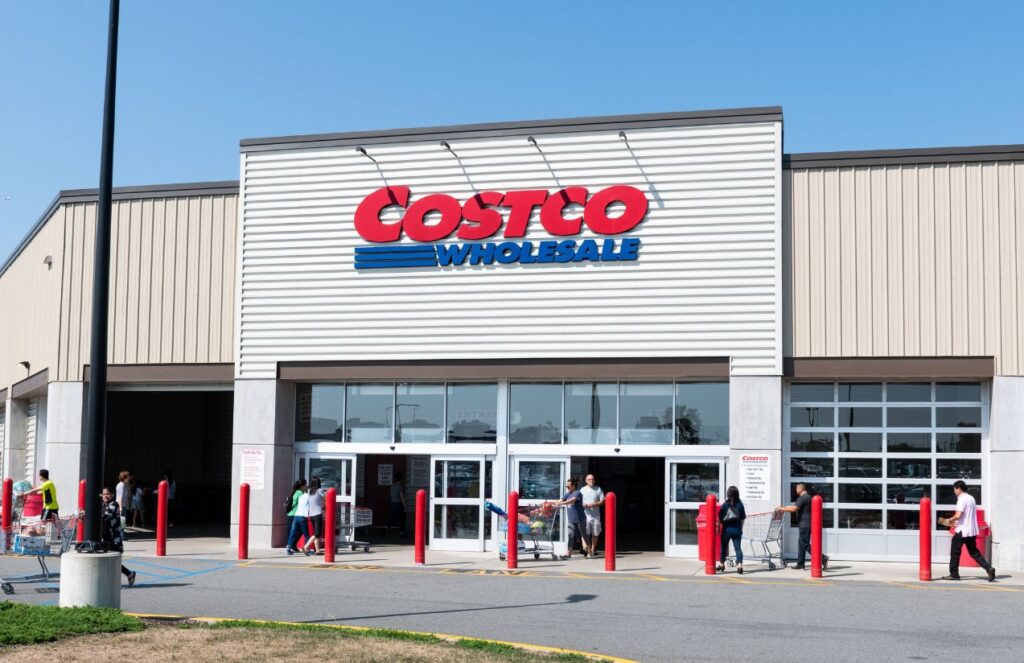 A photo of the entrance of a Costco with several customers entering the store