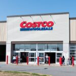 A photo of the entrance of a Costco with several customers entering the store