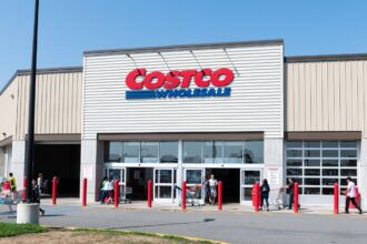 A photo of the entrance of a Costco with several customers entering the store