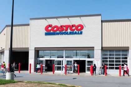A photo of the entrance of a Costco with several customers entering the store