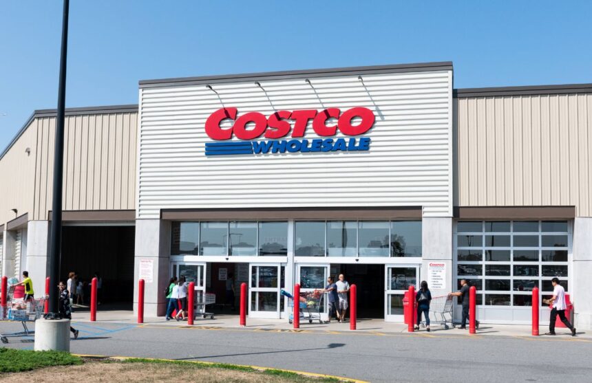A photo of the entrance of a Costco with several customers entering the store