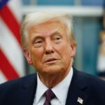 Donald Trump with a very peculiar expression, staring at a fixed point in his office