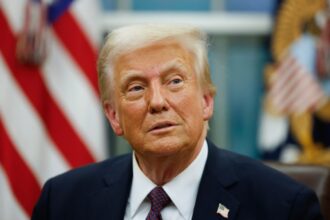 Donald Trump with a very peculiar expression, staring at a fixed point in his office