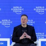 Elon sitting in the middle of a forum, speaking with his followers and visitors