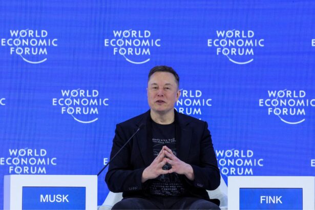 Elon sitting in the middle of a forum, speaking with his followers and visitors
