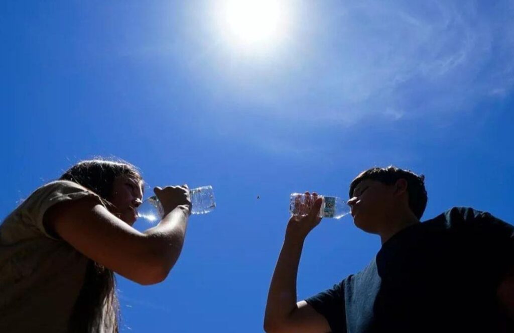 Extreme heat alert: Authorities issue warnings as dangerous temperatures hit the United States Two people drinking bottles of water after the intense heat wave hitting them