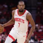 Kevin Durant focused and holding the ball while running toward the opponent’s basket