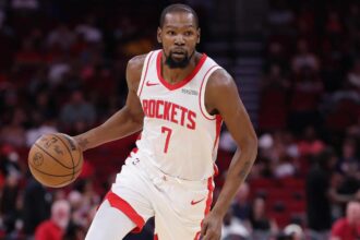 Kevin Durant focused and holding the ball while running toward the opponent’s basket