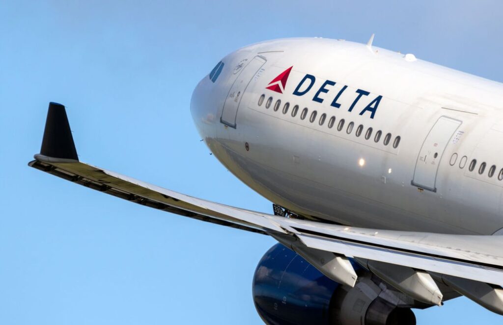 the front part of a Delta airplane being photographed while the aircraft is in flight